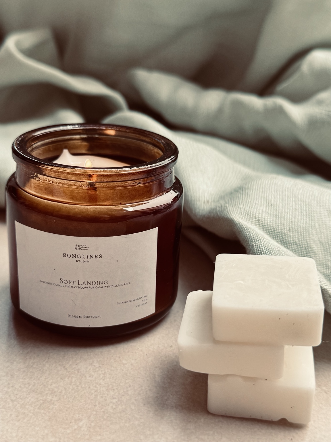 Songlines Soft Landing candle beside three wax melts